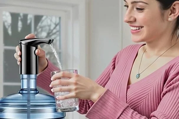 A woman fills a glass from a five-gallon bottle with a Redsack pump